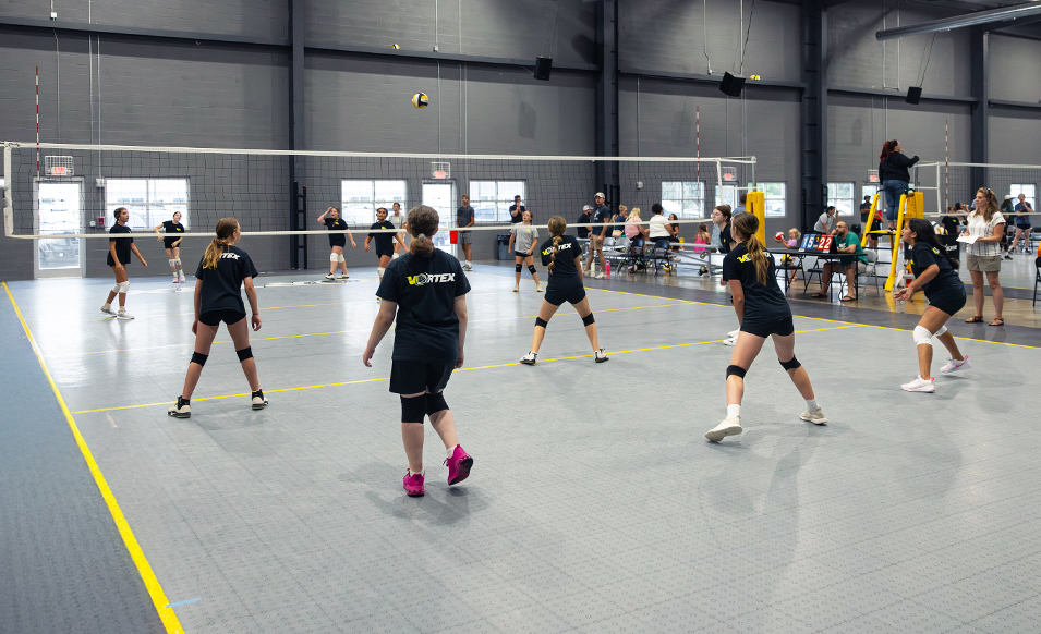 Young Volleyball Team Playing Game on Gray, Yellow, and Black Volleyball court