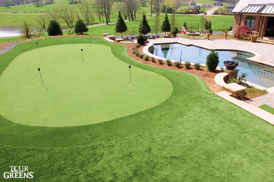 Large backyard with a poolside tour quality putting green
