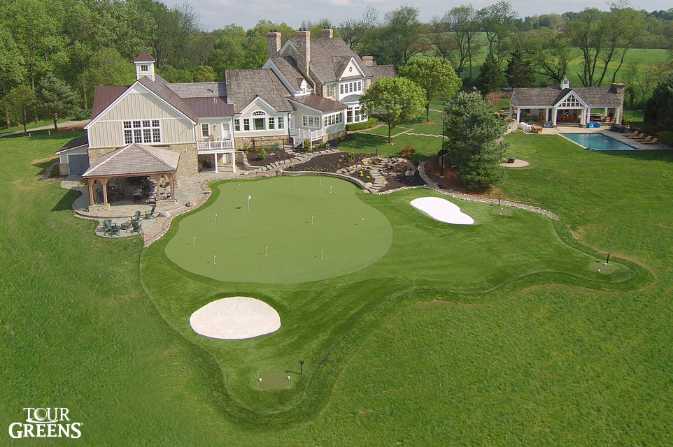 Large backyard with a putting green with sand traps and bunkers