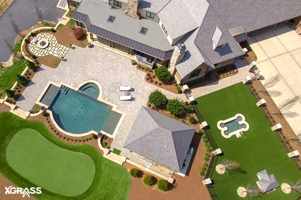 Luxury home with a backyard putting green next to the pool