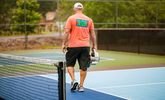 older man walking across pickleball court